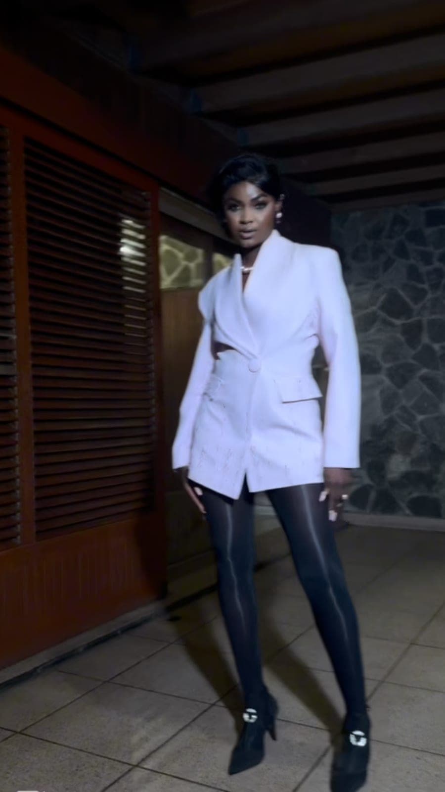 Woman in a tailored white blazer and black leggings for Pink October